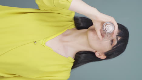 Vertical-video-of-The-woman-is-drinking-water.